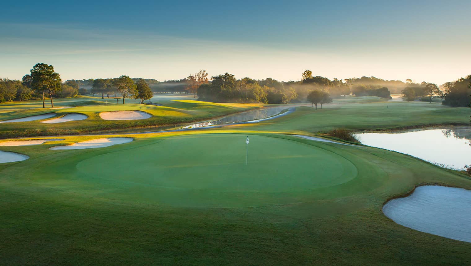 Panoramic view of Walt Disney World Golf Resort at golden hour with manicured fairways and shimmering lakes